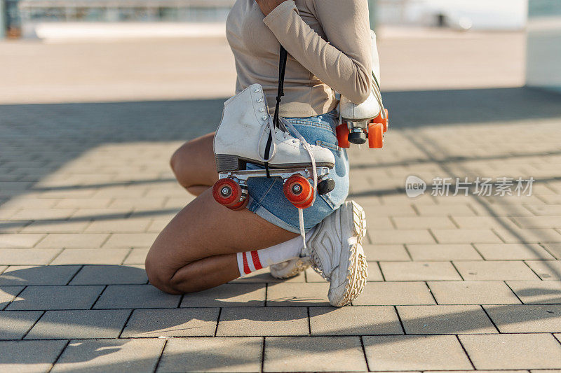 Young Spanish woman rollerblading on the promenade by the sea.